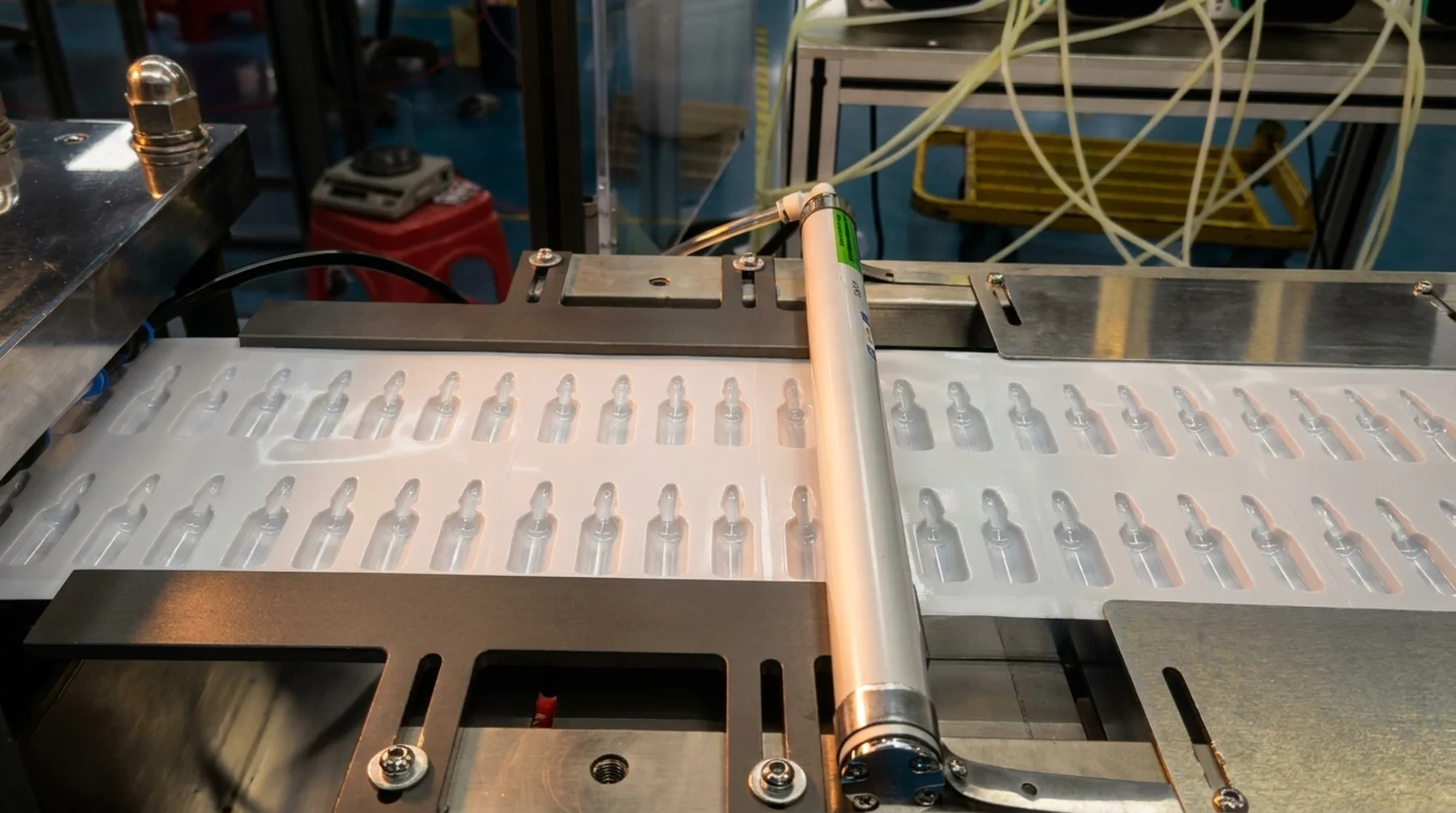 Film with ampoule-shaped cavities passing beneath a guide roller