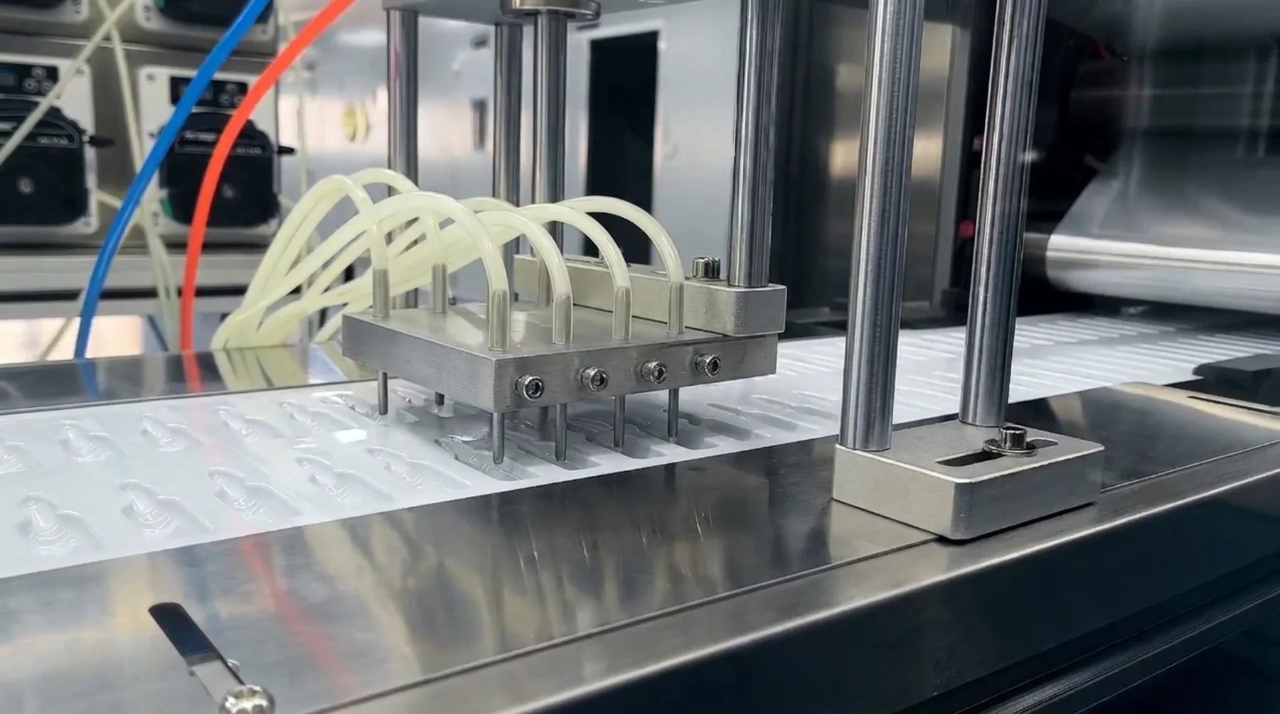 Multiple dosing nozzles and supply tubes positioned above open packaging cavities