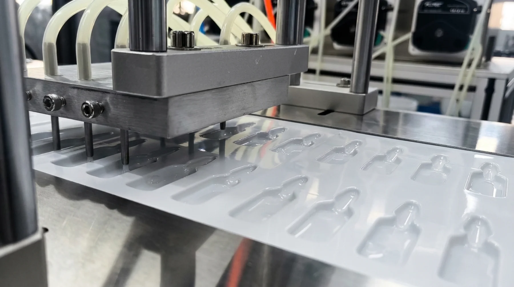 Close view of dosing nozzles aligned with cavities in the film
